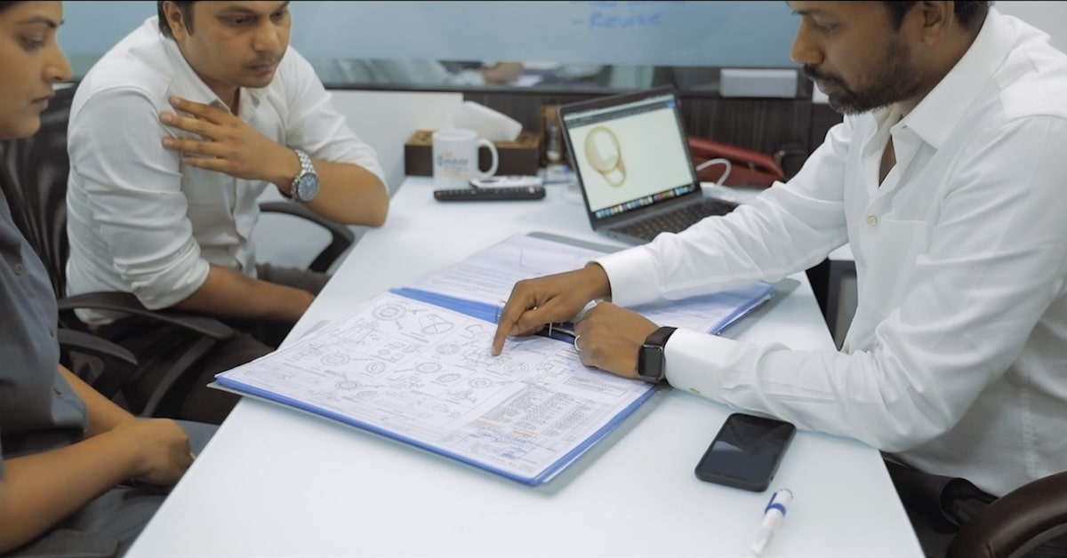 APChemi engineers reviewing pyrolysis plant design blueprints with CAD models